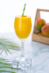 Fresh mango juice in a glass with ice cubes 