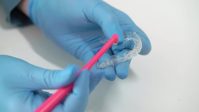 The dentist cleans his teeth with a toothbrush. Typodont, model of an artificial jaw. Dentistry dental clinic. Health care. Aligners