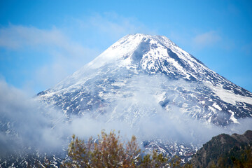 Fototapeta na wymiar View of the Villarrica volcano during the autumn season with snow on its summit.