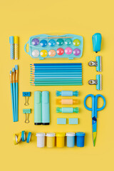 Fototapeta premium Various colorful material for creativity and art activity is arranged neatly on yellow background. Stationery and supplies for drawing and craft. Workplace organization.
