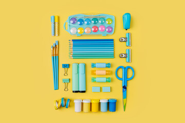 Various colorful material for creativity and art activity is arranged neatly on yellow background.  Stationery and supplies for drawing and craft. Workplace organization.