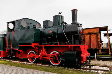 Classic steam engine at an open-air railway yard.
