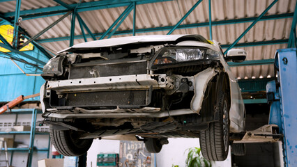 Saloon lifted up to prepare to inspect the damage caused by an accident. lift is parked waiting for repairs in car repair. That has standards to be repaired by expert technicians to return to normal.