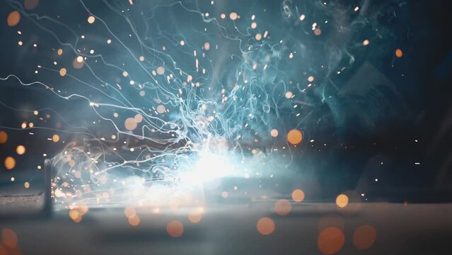 The man is welding. Welding with argon or electrode, using a welding machine. Sparks and flashes fly.