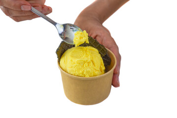 Hand with spoon holding piece of of homemade Mango ice crem isolated on white background