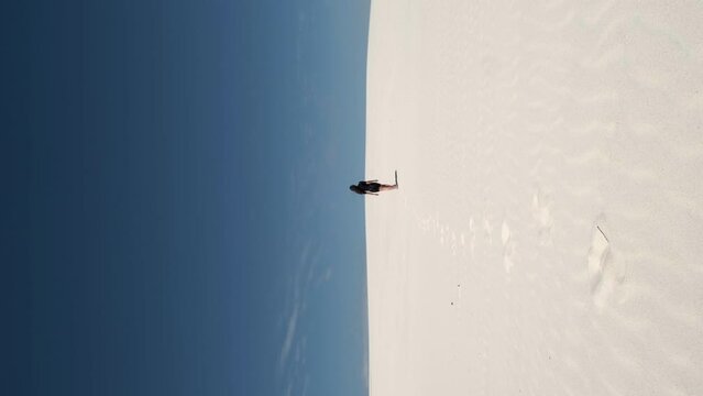 Shot european fitness runner running on desert sand dunes. A runner trains an athlete in nature. Slow motion
