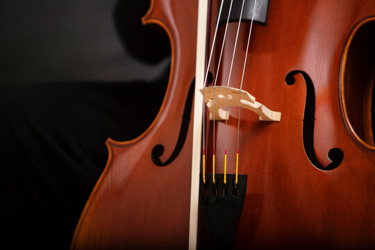 Classic cello with bow on black background