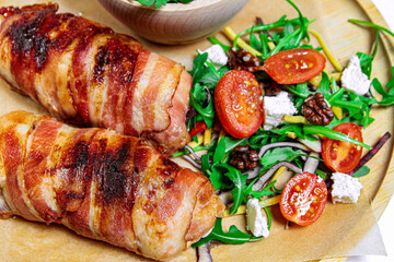 Pork rolls wrapped in bacon served with salad