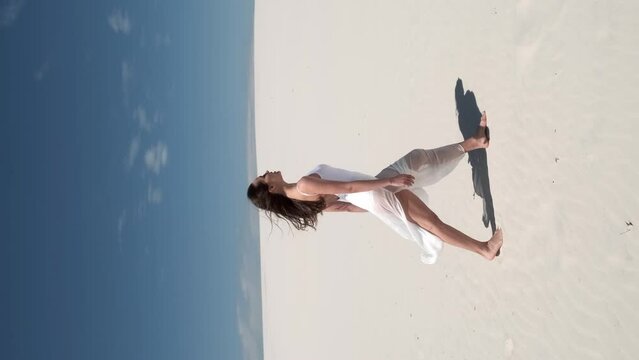 Silhouette Young woman running through the desert. Brunette with long flowing hair. The dress flutters in the wind. Blue sky. footprints in the sand