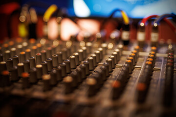 Sliders and knobs at an audio mixing console.