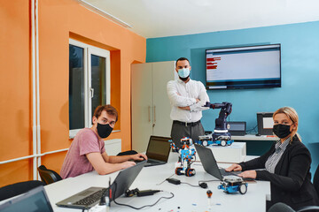 A group of colleagues working together in a robotics laboratory, focusing on the intricate fields of robotics and 3D printing. Showcase their dedication to innovation, as they engage in research