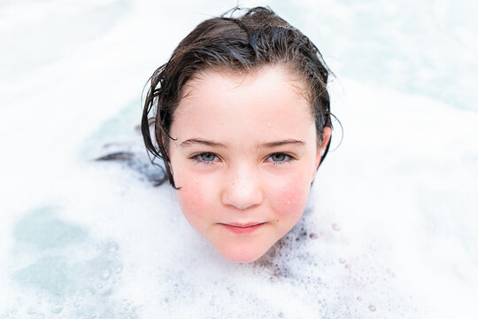 Charming girl enjoying bathing in hot tub
