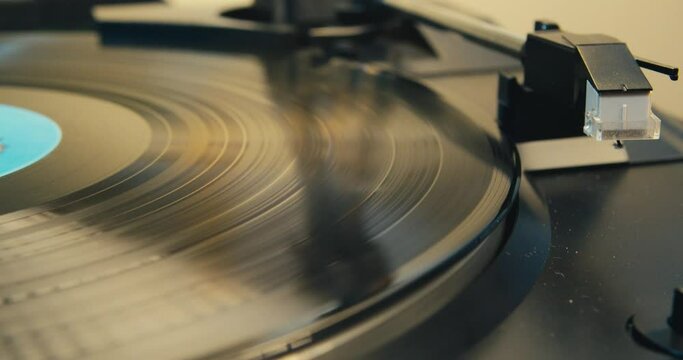 Record Player Vinyl Playing Gramophone. Vinyl Record on Spinning on a Vintage Turntable, Listening to Music on a Gramophone. Retro Music Player on Living Room Home Background in Evening. 