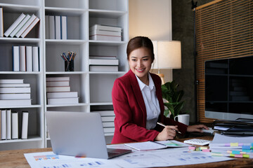 Smile Pretty business Asian woman is working her job on a laptop computer in a modern office. Doing accounting analysis report real estate investment data, Financial and tax systems concept