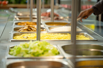 Asian food buffet in restaurant multiple food dishes and salad.