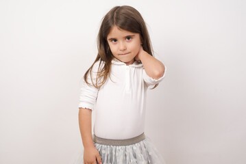 Cute charming little girl wearing white shirt over white background feeling anxious or nervous...