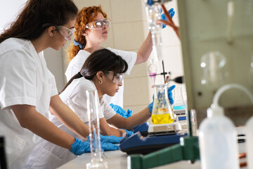 Group of female chemistry scientists doing experiments in the lab.	
