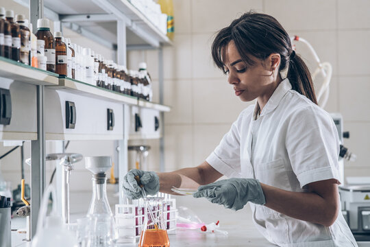Female chemistry scientist doing experiments in lab.	