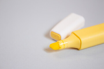 Yellow marker isolated on grey background. Yellow felt-tip pen, closeup.