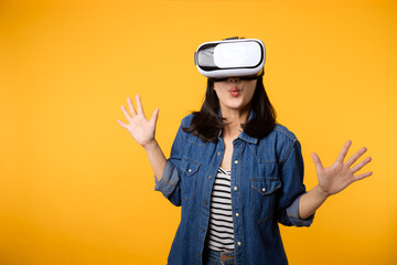 Young asian woman get experienced wearing virtual reality headset game entertainment isolated on yellow background. Winner of cyber future video game concept.
