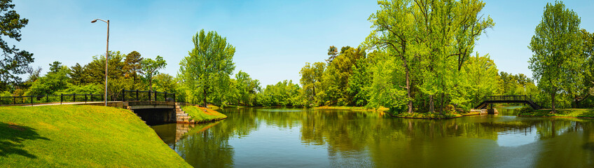 Fototapeta na wymiar Tranquil spring landscape along the riverbank of Roosevelt Lake at Roger Williams Park, Providence, Rhode Island