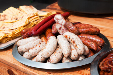 Set of appetizing fried grilled sausages on a wooden background. Oktoberfest food, pub concept....