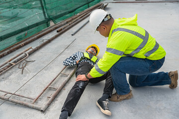 Workers at construction sites fall from heights, fall from scaffolding, injure their hips. with construction supervision engineers hurrying to help first aid in the first place Accidents at work.