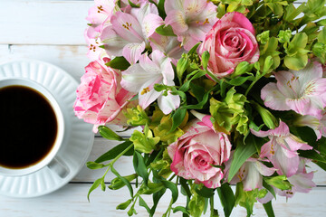 Pink rose arrangement bouquet flowers on a table or desk with coffee