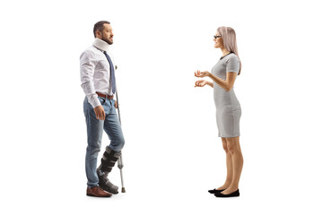 Fototapeta premium Full length profile shot of a young woman talking to an injured man with an orthopedic boot and cervical collar