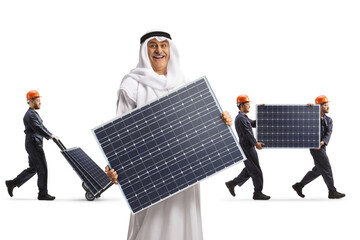 Arab man holding a photovoltaic panel and workers carrying panels in the back