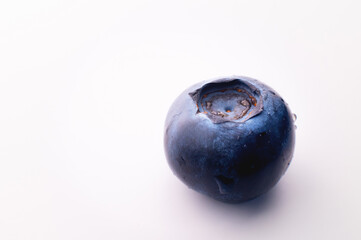 One blueberry, on a white background. Ripe fresh blueberries close up