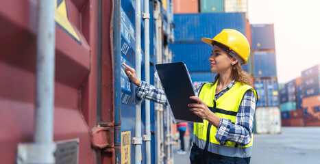 Women Engineer wears PPE checking container storage with cargo container background at sunset. Logistics global import or export shipping industrial concept.