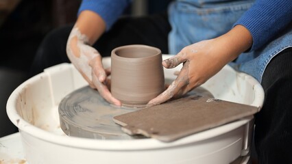 Fototapeta na wymiar Professional craftsman potter making jug on potter wheel circle