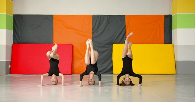 Little girls practice at gymnastics class in a studio