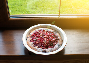 Obraz na płótnie Canvas Fresh cherry pie on the windowsill in the house. Delicious homemade pastry.