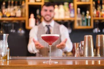 Barman presenting his new cocktail to sell in his restaurant. Concept: lifestyle, activity, drinks.