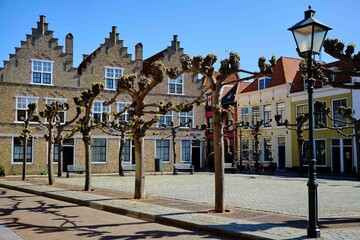 Fototapeta premium Typical old Duch houses in the town Vlissingen around a square with trees