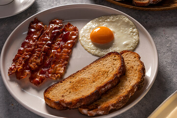Breakfast with fried Bacon and Eggs, toast, and Coffee