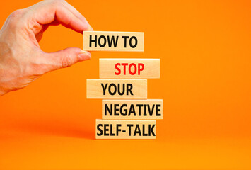 Stop negative self-talk symbol. Concept words How to stop your negative self-talk on wooden block. Psychologist hand. Beautiful orange background. Psychological negative self-talk concept. Copy space