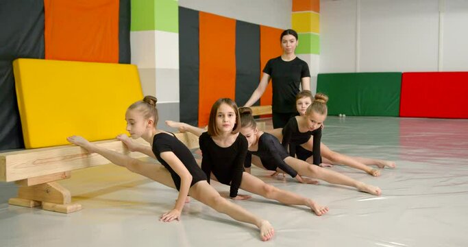 Little girls practice at gymnastics class in a studio