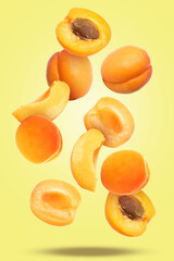 Flying apricots on yellow background