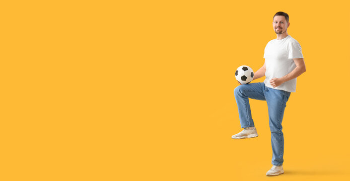 Man playing with soccer ball on yellow background with space for text