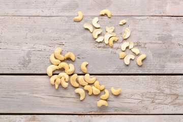 Tasty cashew nuts on light wooden background