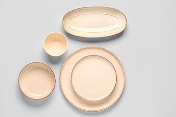 Composition with clean plates and bowl on grey background