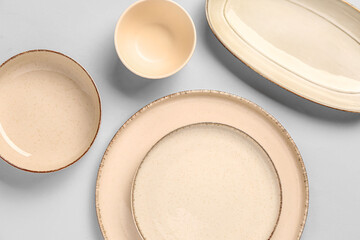 Composition with clean plates and bowl on grey background