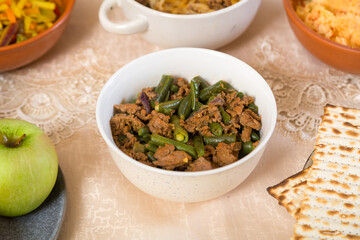 Vegetables stewed in spices with meat and garlic on a laid table.