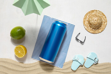 Can of soda with beach decor and sand on white background