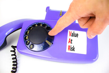 VAR Value at risk symbol. Concept words VAR Value at risk on beautiful old disk phone. Businessman hand. Beautiful white table white background. Business and VAR Value at risk concept. Copy space.