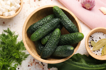 Bowl with fresh cucumbers for preservation on light background