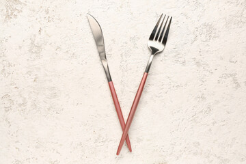 Stainless steel fork and knife with pink handles on white background